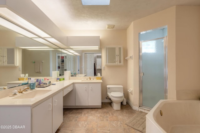 bathroom featuring a garden tub, toilet, a sink, double vanity, and a stall shower