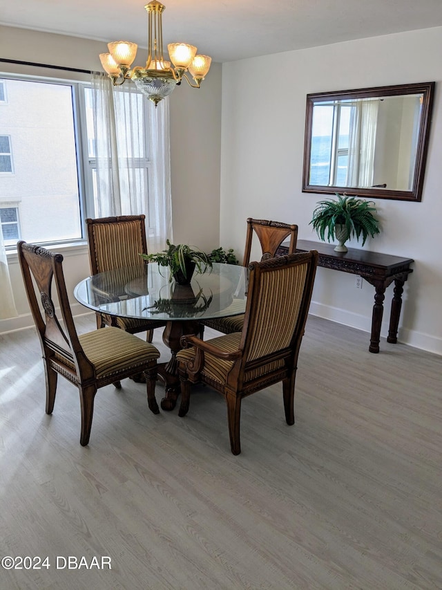 dining space featuring wood-type flooring and a notable chandelier