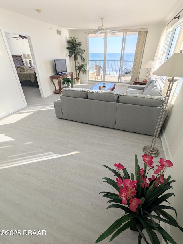 living room featuring light hardwood / wood-style floors and ceiling fan