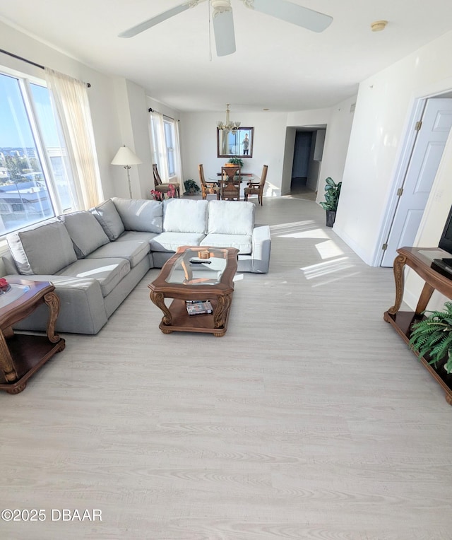 living room featuring a wealth of natural light, ceiling fan, and light wood-type flooring