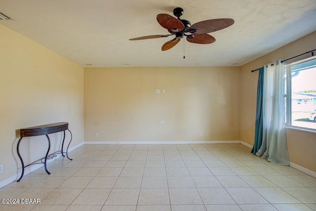 tiled empty room featuring ceiling fan