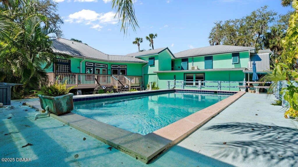 view of pool with french doors, a deck, and a patio