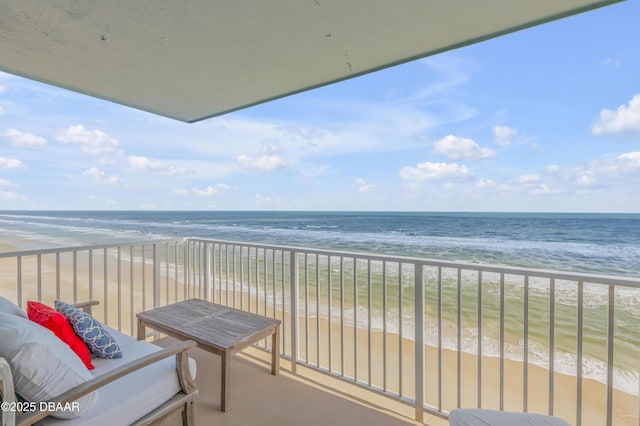 balcony featuring a water view and a beach view