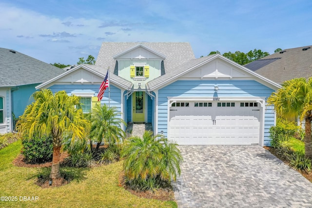 1082 Castaway Ct, Daytona Beach, FL 32124 - view of front facade with board and batten siding, an attached garage, roof with shingles, and driveway