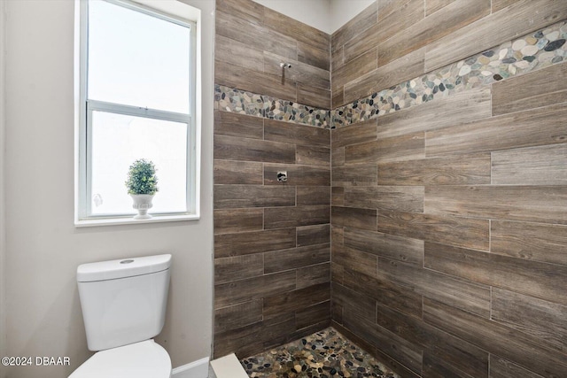 bathroom with tiled shower and toilet