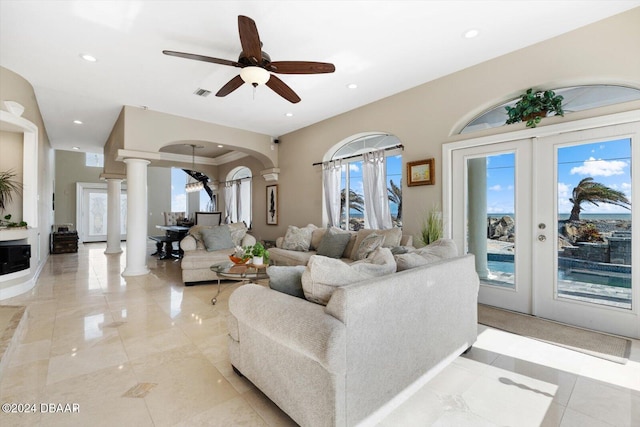 living room featuring french doors, ceiling fan, and ornate columns