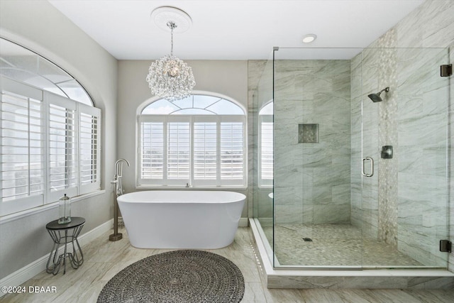 bathroom featuring a chandelier and separate shower and tub