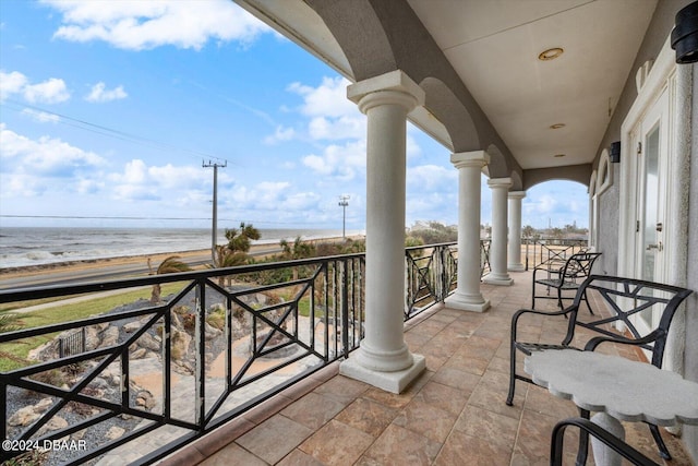 balcony with a water view and a beach view