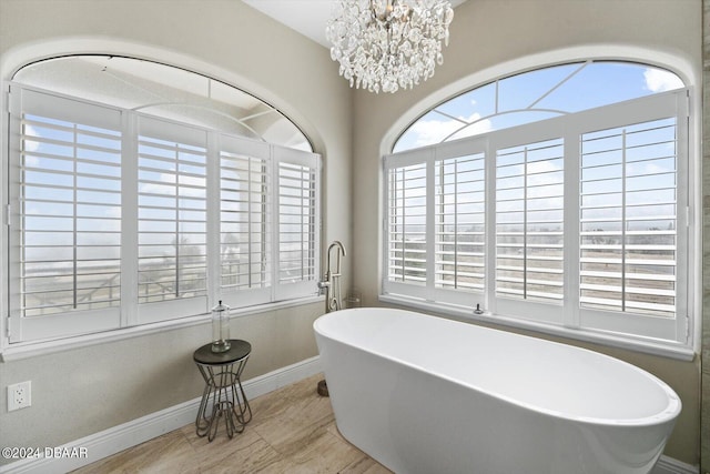 bathroom featuring a bath and a notable chandelier