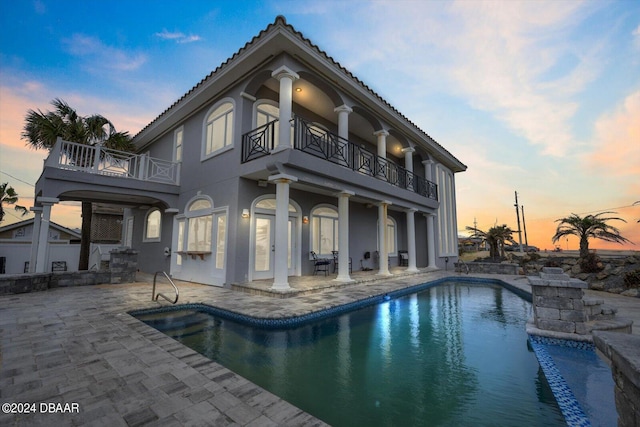 pool at dusk with a patio