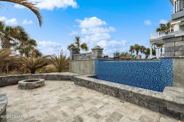 view of swimming pool featuring a fire pit and a patio area