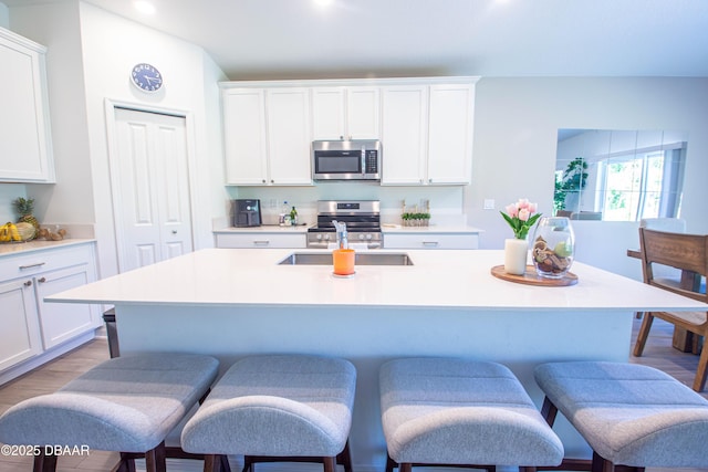 3963 Willowbrook Dr, Edgewater, FL 32141 - kitchen featuring stainless steel appliances, a sink, a kitchen breakfast bar, light countertops, and white cabinets