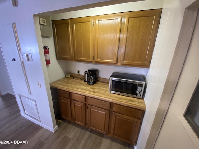 55705 Keith St, Astor, FL 32102 - kitchen featuring visible vents, light countertops, dark wood-style floors, brown cabinets, and stainless steel microwave
