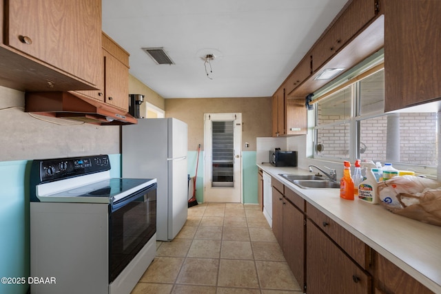 kitchen with sink, light tile patterned floors, and range with electric cooktop