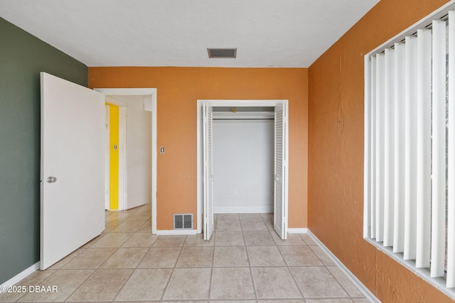 unfurnished bedroom with a closet and light tile patterned flooring