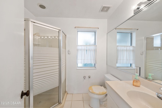 bathroom featuring vanity, toilet, tile patterned flooring, and a shower with door