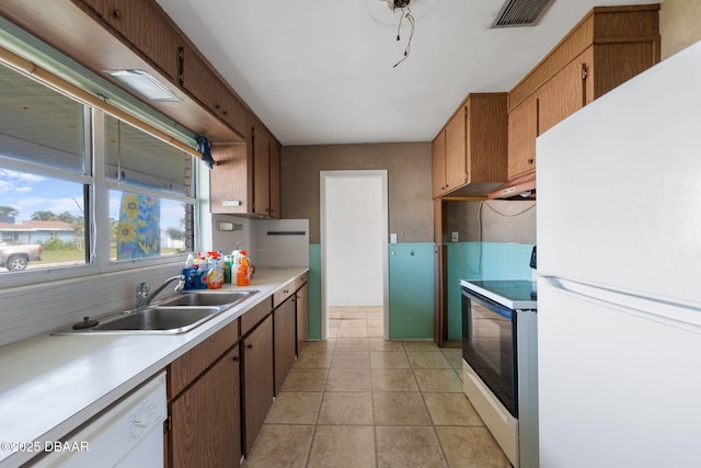 kitchen featuring sink, light tile patterned floors, backsplash, and white appliances