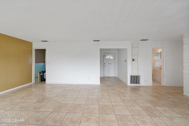 tiled spare room with wooden walls and a textured ceiling