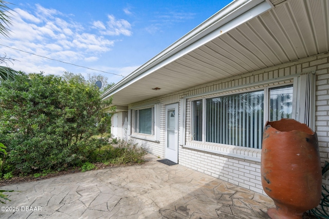 view of exterior entry with a patio