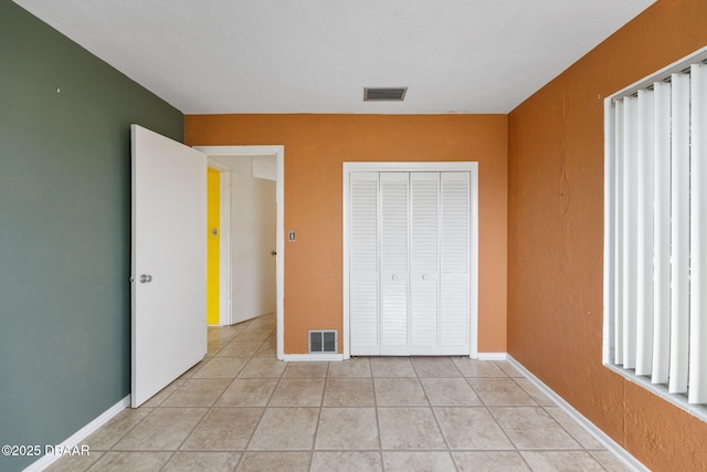 unfurnished bedroom with a closet and light tile patterned floors