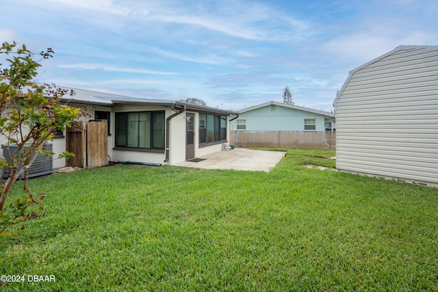 rear view of house featuring a sunroom, cooling unit, a patio area, and a yard