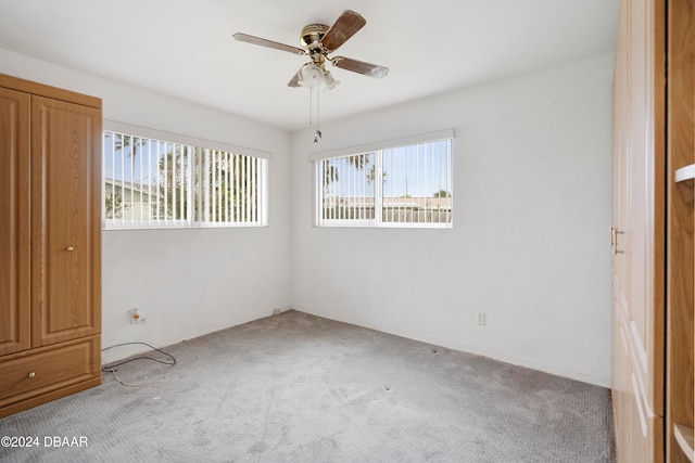 carpeted empty room featuring ceiling fan