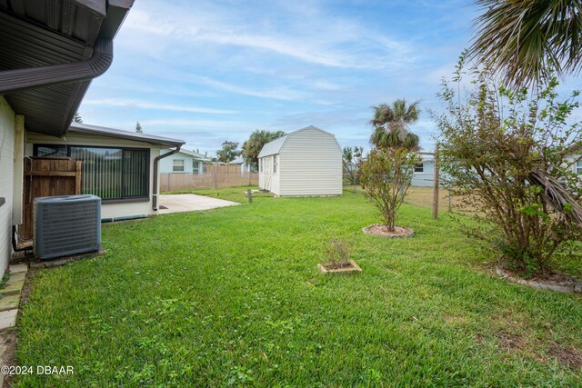 view of yard with central AC unit, a storage shed, and a patio