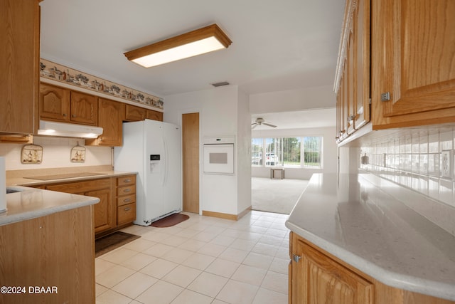 kitchen featuring ceiling fan, backsplash, kitchen peninsula, white appliances, and light tile patterned flooring