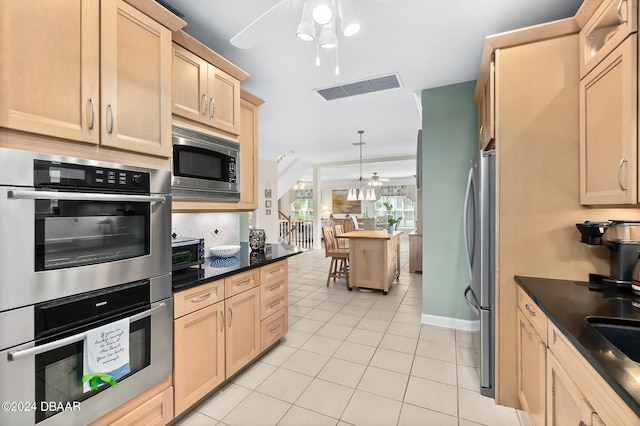 kitchen featuring stainless steel appliances, light tile patterned floors, ceiling fan, pendant lighting, and light brown cabinetry