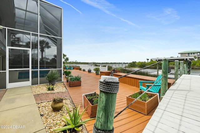 deck featuring a water view and glass enclosure