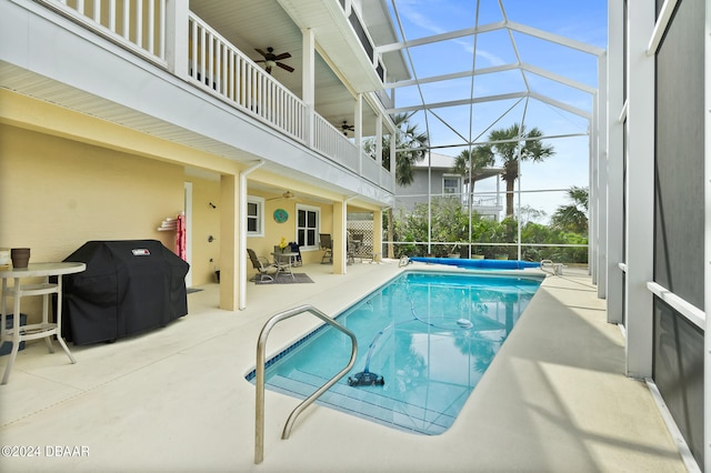 view of pool with ceiling fan, area for grilling, a lanai, and a patio area