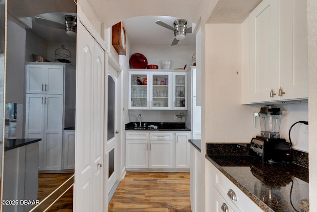 3102 N Springwater Ct N, Port Orange, FL 32128 - kitchen with light wood-type flooring, ceiling fan, and white cabinetry