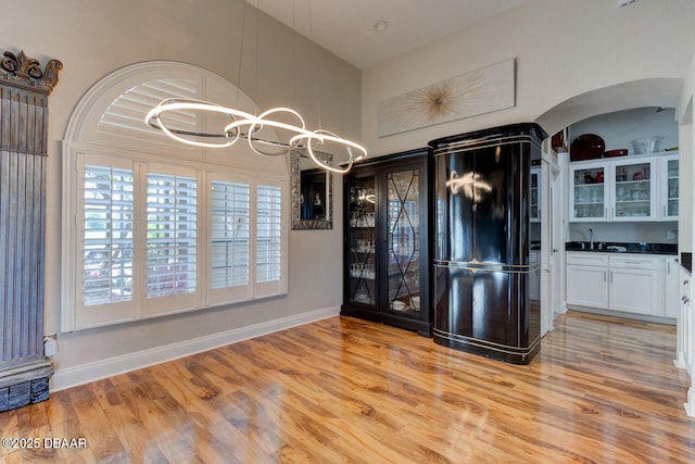3102 N Springwater Ct N, Port Orange, FL 32128 - entryway featuring a chandelier, light wood-style floors, arched walkways, and a towering ceiling