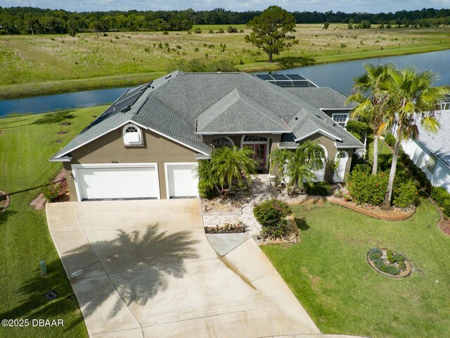 3102 N Springwater Ct N, Port Orange, FL 32128 - view of front of home with a water view, concrete driveway, roof with shingles, and stucco siding