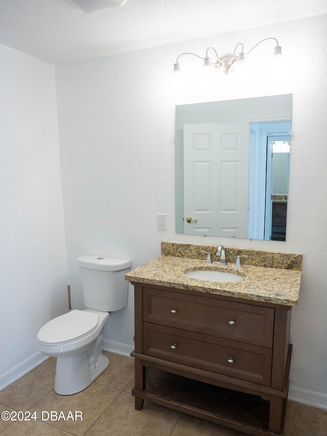 bathroom featuring tile patterned floors, vanity, a textured ceiling, and toilet