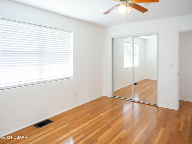 unfurnished bedroom featuring hardwood / wood-style flooring, ceiling fan, and a closet