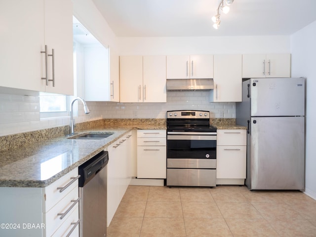 kitchen with white cabinets, sink, light stone countertops, light tile patterned floors, and stainless steel appliances