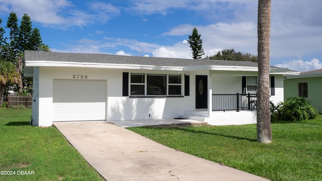 ranch-style home with a front lawn, covered porch, and a garage