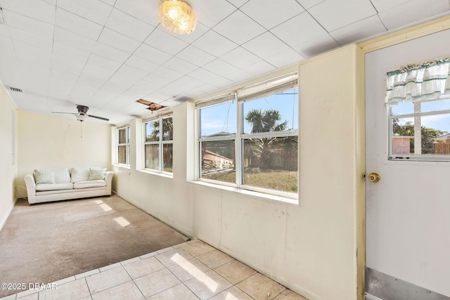 unfurnished sunroom featuring visible vents and a ceiling fan