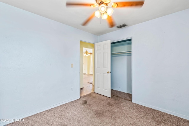 unfurnished bedroom featuring carpet floors, a ceiling fan, visible vents, baseboards, and a closet