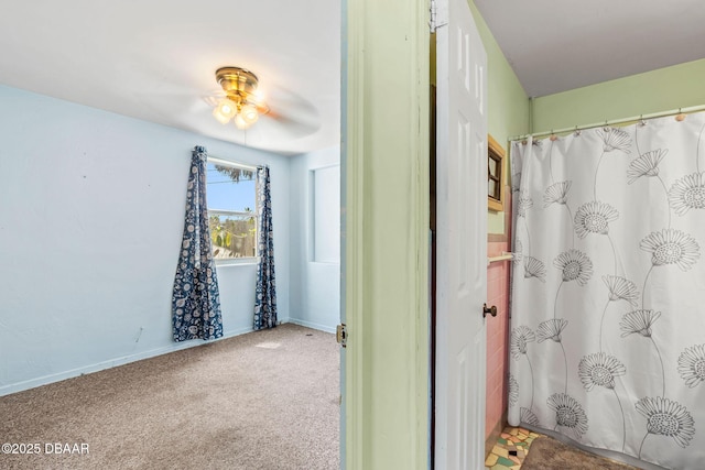 bathroom featuring a shower with curtain, ceiling fan, and baseboards