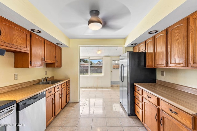 kitchen featuring stainless steel appliances, brown cabinets, and a sink