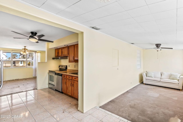 kitchen featuring under cabinet range hood, light colored carpet, stainless steel appliances, open floor plan, and brown cabinets