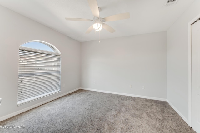 carpeted spare room with ceiling fan