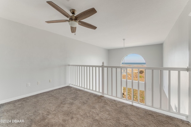 carpeted spare room with ceiling fan