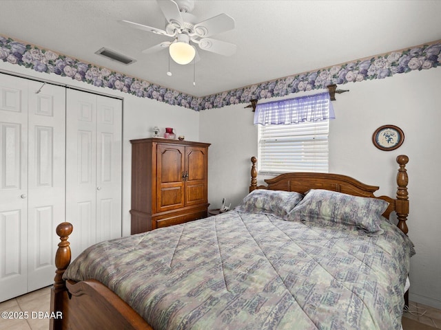 bedroom featuring ceiling fan, a textured ceiling, a closet, and light tile patterned flooring