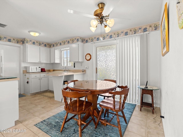 dining room featuring ceiling fan, light tile patterned floors, and sink