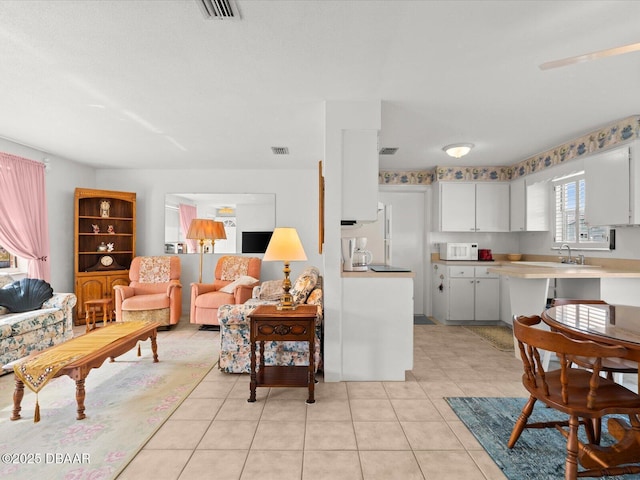 living room featuring sink and light tile patterned floors