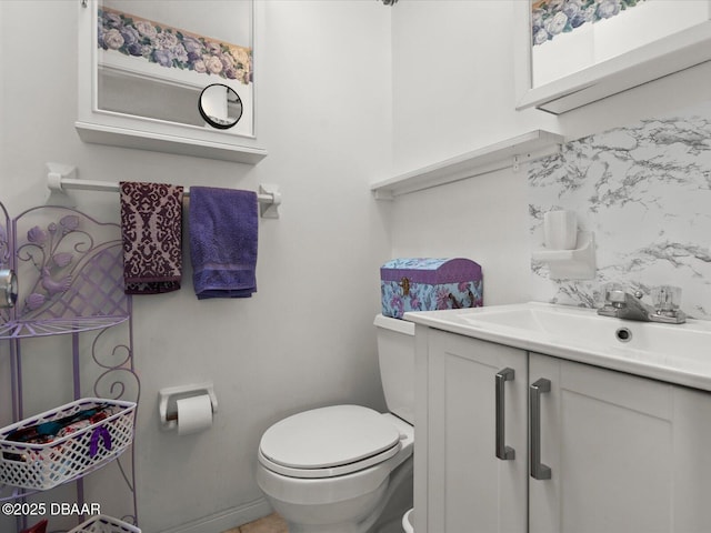 bathroom featuring toilet, decorative backsplash, and vanity