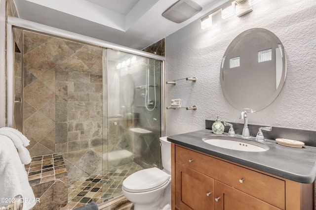 bathroom featuring vanity, toilet, and a shower with door